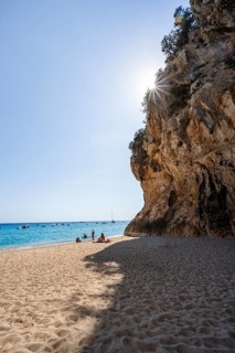 Sandy beach beach and steep cliffs with caves at Cala Luna, Sun Star, Golfo di Orosei, Baunei,