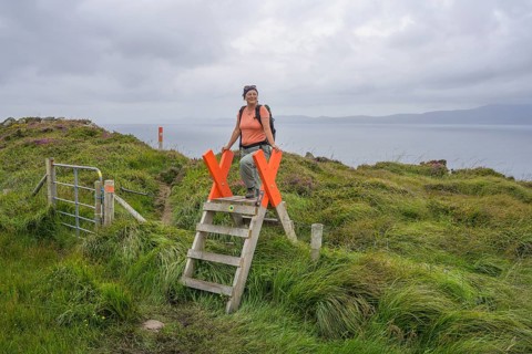 Crossing a fence while hiking to the lighthouse of, Sheepshead, County Cork, Ireland