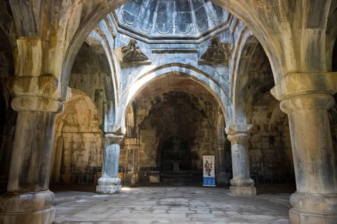 Historic interior with arched stone arches, through which rays of light create a mystical