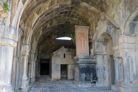 Vaulted stone building with decorated arches and historic reliefs in old walls, Haghpat monastery,