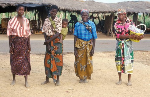 Local woman with a toddler pose for the camera in front of a street market, Salima, Malawi, Africa,