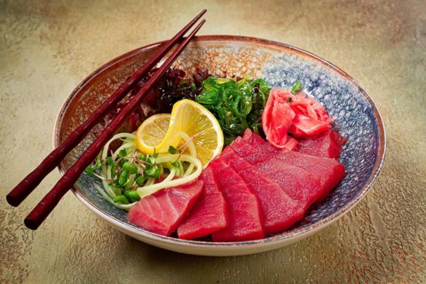Tuna sashimi with daikon and wakame salad, pickled ginger, in a bowl