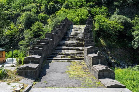 Historic stone staircase leads through a wooded landscape covered with moss, bridge, Sanahin bridge