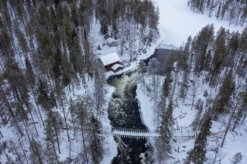 Aerial view over Myllykoski water mill along the river Kitkajoki in winter, Oulanka National Park,
