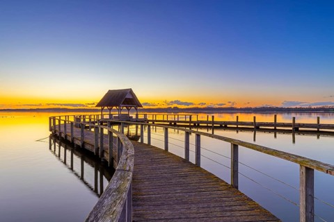 Wooden jetty on Lake Hemmelsdorf / Hemmelsdorfer See at sunrise in spring near LÃ¼beck,