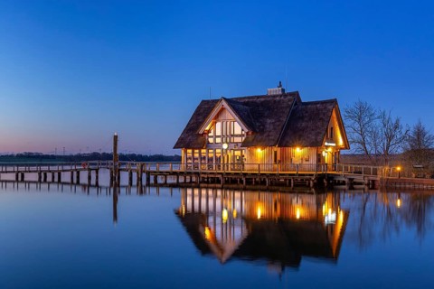 LakehouseÂ°54, bistro and bar on Lake Hemmelsdorf / Hemmelsdorfer See at sunrise in spring near
