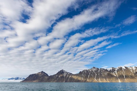 White clouds over mountains along Lilliehöökfjorden, fjord branch of Krossfjorden in Albert I Land,