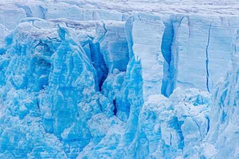 Calving glacier wall showing crevasses, deep cracks in blue ice, Lilliehöök Fjord, Krossfjorden in