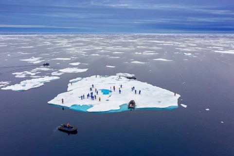 Aerial view over ecotourists from Iceland Pro Cruises walking on ice floe drifting in the Arctic