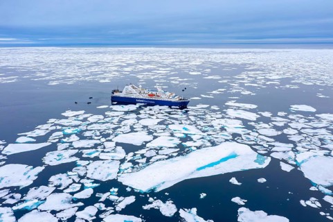 Aerial view over cruise ship Ocean Diamond from Iceland Pro Cruises sailing among drift ice / brash