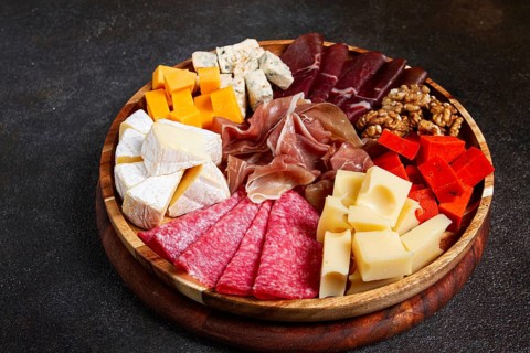 Assortment of cheese meat cuts, on a plate, top view, no people