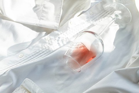Glass, with pink wine, spilled on a white shirt, close-up, selective focus, no people, concept, top