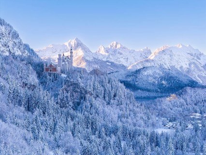 View of Neuschwanstein Castle in a vast, snowy mountain landscape. Impressive winter panorama,