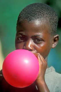 Local boy inflating balloon, Kande, Malawi, Africa, July 2000, vintage, retro, old, historic