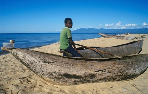 Local boy sitting on a dugout near Kande Beach on Lake Malawi, Malawi, Africa, July 2000, vintage,