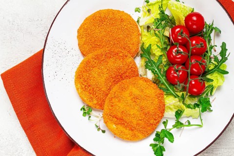 Crispy fried fish cutlets, fish burgers, on a white plate, with fresh lettuce leaves, arugula and