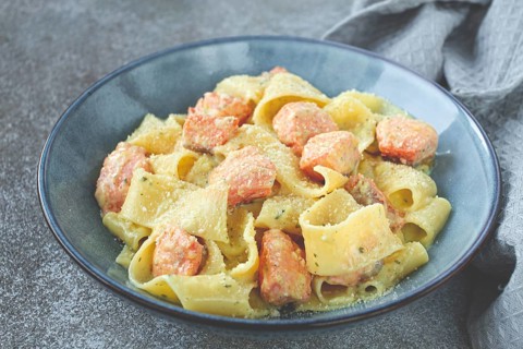 Papardelle pasta, in creamy sauce with salmon, natural light, lifestyle, homemade, on a gray