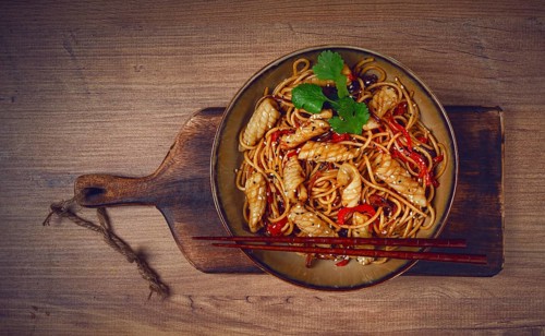 Udon noodles, with squid and vegetables, on a wooden table, homemade, no people