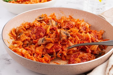 Bigos, Polish dish bigos, on the table, pan with stewed meat, with cabbage, chorizo sausages,
