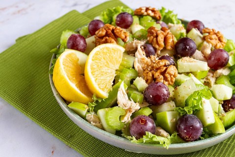 Fresh Waldorf salad, celery stalk with chicken, apple and walnuts, grapes, herbs, homemade, without