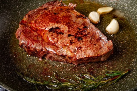 Fried steak, beef steak, rib eye steak, in a frying pan, top view, no people