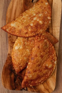 Fried chebureks, close-up, on a wooden chopping board, no people