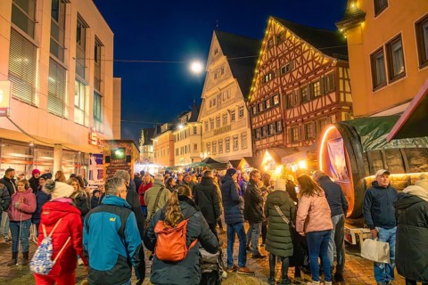 People enjoy the busy Christmas market in a half-timbered house town at night, Christmas market