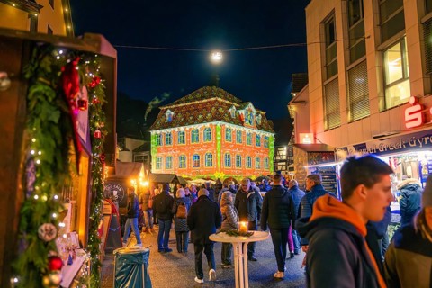 Building with festive light projection on a busy Christmas market, Christmas market 2025, Nagold,