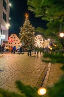 Glowing Christmas tree and Ferris wheel frame a square at night, Christmas market 2025, Nagold,