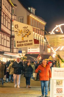 People buy stomach bread at a busy evening Christmas market, Christmas market 2025, Nagold, Black