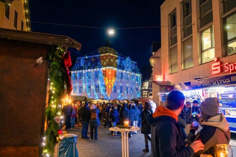 Coloured projections on a building during a night-time visit to the Christmas market, Christmas