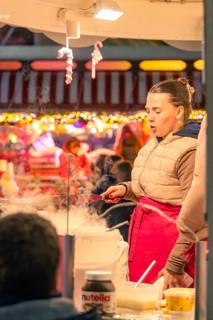 Woman preparing cotton candy at a festive Christmas market, Christmas market 2025, Nagold, Black