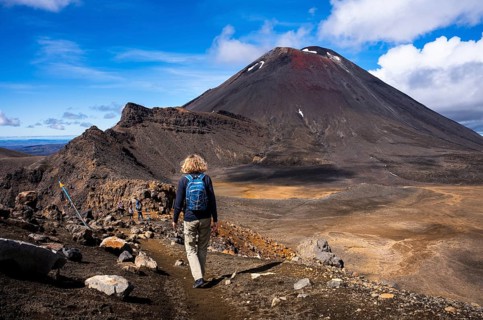 A hiker on the Tongariro Alpine Crossing trail. View of Mt Ngauruhoe. Tongariro National Park.