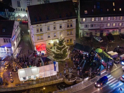 Square with illuminated Christmas tree and people gathered at night, Aidlingen Christmas market,