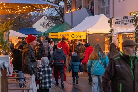 Crowd of people at a cozy Christmas market in the evening, Aidlingen Christmas market, Böblingen