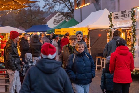Happy crowd at an illuminated market in a Christmas evening mood, Aidlingen Christmas market,