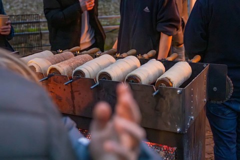 Several trdelnÃ­k pastries prepared on a market stand at night, Aidlingen Christmas market,