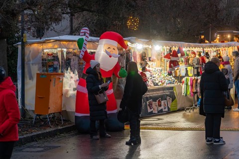 Christmas market with Santa Claus decoration and illuminated stalls in the evening, Aidlingen