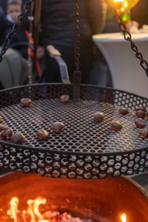 Roasting chestnuts over a fireplace at dusk, Aidlingen Christmas Market, Böblingen District,