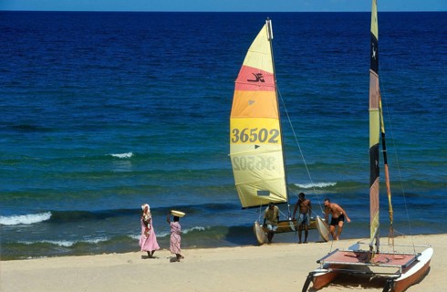 Local woman and tourist with catamaran on Lake Malawi, Kande, Malawi, Africa, July 2000, vintage,