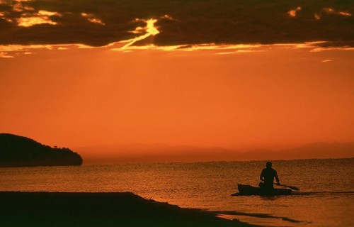 Sunrise over Lake Malawi near Kande, man in dugout, Kande, Malawi, Africa, July 2000, vintage,