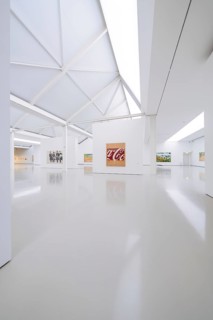 Spacious gallery with modern architecture and exhibited works of art under bright light, Open