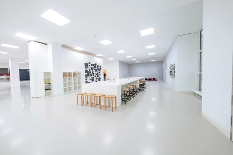 Large, bright room with long tables and chairs, minimalistic modern furniture, Open Horizons