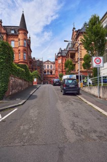 Houses, historic residential buildings, concrete wall, brick wall, trees, hedge, zone 30 sign,