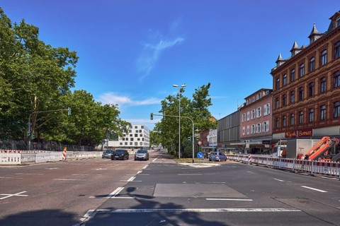Traffic light intersection, central island, fenced construction site, barrier, road construction,