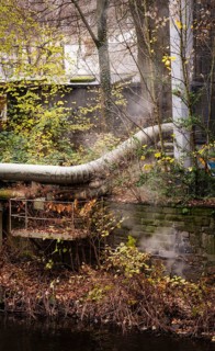 District heating pipeline in front of old industrial buildings on the banks of the Wupper,