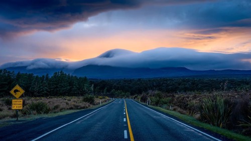 Mount Ngauruhoe in the morning at sunrise with glowing clouds, road SH 47. Tongariro National Park,