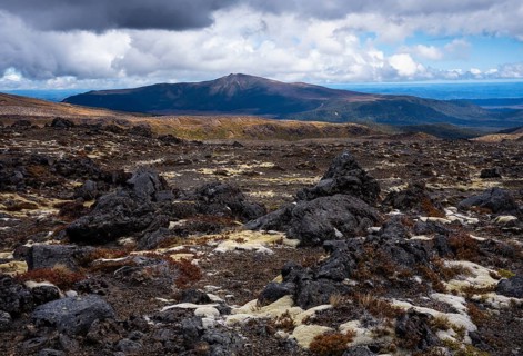 Volcanic landscape along Bruce Road. Different colored braids on rocks. In the back, Mount