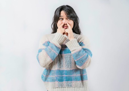Asian woman with face of unpleasant odors, covering nose. Person covering nose because bad smells.