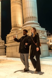Young happy interracial couple enjoying a romantic date night, walking arm in arm and exploring the